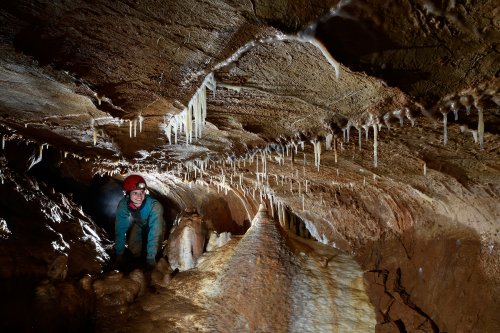 Tropfsteinhöhle (Allemagne) - Progression dans un passage étroit concrétionné.(SP-18-0599)