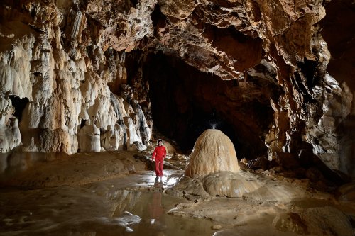 Grotte de Lombrives (Ariège) - Galerie du cimetière : eau tombant sur un imposant dôme de calcite (avec personnage à côté)(SP-18-1383)