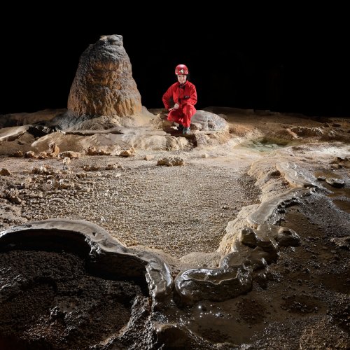Grotte de Lombrives (Ariège) - Gour avec petits cailloux calcifiés en train de se transformer en perles  (personnage en arrière plan)(SP-18-1426)