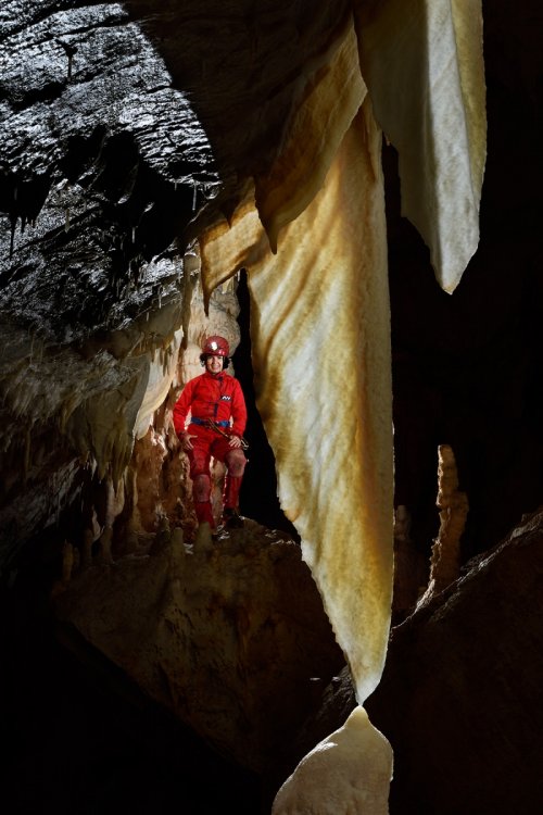 Pestera Topolnita (réseau supérieur) - Grande draperie translucide avec spéléo en arrière plan(SP-18-1900)