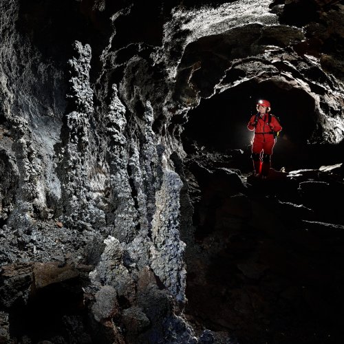 Mont Fuji lava tube (Mont Fuji, Japon) - Groupe de stalagmites de lave massives sur le côté d'une galerie (spéléo en arrière plan)(SP-19-0376)