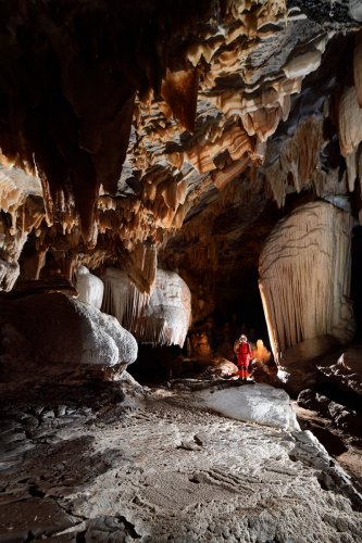 Grotte du Sud de l'Arizona (USA) - Spéléo dans grande galerie concrétionnée avec petits gours blancs  en premier plan et draperies au plafond(SP-20-0152)