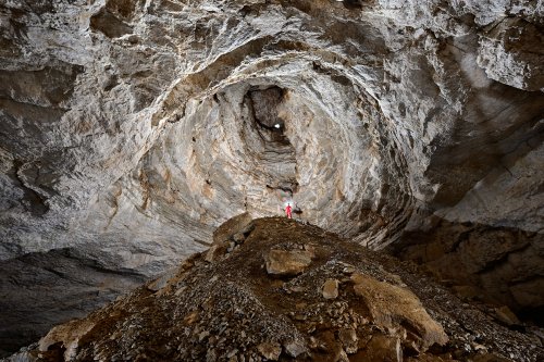 Gouffre des Ravières (Doubs) - Spéléo perché sur le grand cône d'éboulis à la base du puits d'entrée (puits d'effondrement) (SP-20-0349)