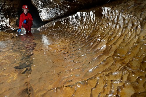 Rivière de la Vieille Folle (Doubs) - Détail de coups de gouge sur le sol de la galerie (spéléo en arrière plan)(SP-20-0413)