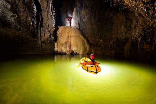 Grotte Sarrazine (Doubs) - Traversée en canot pneumatique du lac d'entrée (avec spéléo perché en haut de la coulée de calcite)(SP-20-0448)