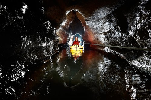 Grotte de la Vieille Folle (Doubs) - spéléo traversant le petit lac en canot   (SP-20-0709)