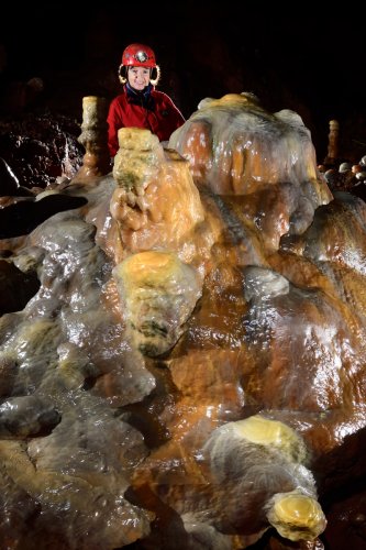 Grotte de Dargilan (Aveyron) - Salle du chaos : massif stalagmitique coloré (avec spéléo en arrière plan)(SP-21-1499)