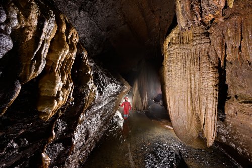 Baume de Gonvillars (Haute Saône) - Progression dans la rivière avec coulées sur les parois  (spéléo en arrière plan)(SP-22-1466)