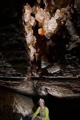 Salt cave (Mont Sodome, Israël) - Spéléo regardant des cristaux de sel colorés dans une fracture au plafond d'une galerie(SP-23-0848)