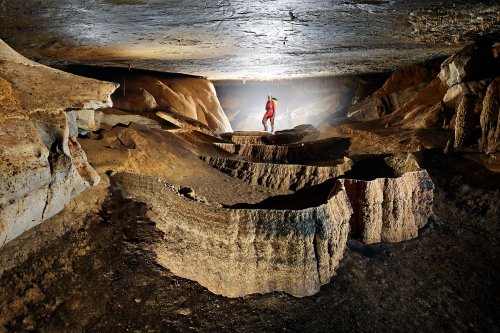 Caverna Paraiso (Para, Brésil) - Galerie avec  barrière de gours secs et spéléo contre jour en fond(SP-23-1129)
