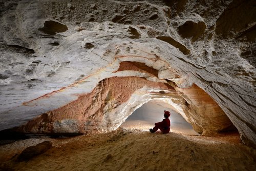 Caverna do Bras (Para, Brésil) - Galerie  de grès clair  avec spéléo assis sur le sol sableux(SP-23-1316)