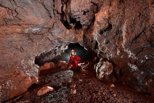 Onça cave (Carajas, Para, Brésil) - Petite galerie d'une cavité dans la latérite avec spéléo en fond(SP-23-1351)