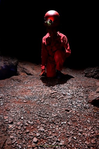 Onça cave (Carajas, Para, Brésil) - Spéléo  regardant un sol de graviers latéritiques  (SP-23-1386)