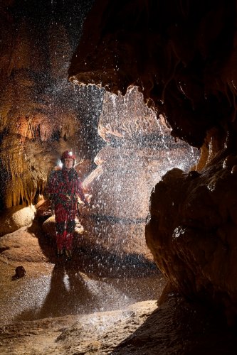 Grotte de l'Olivier (Lot) - Cascatelle en contre jour avec spéléo en arrière plan(SP-23-1790)