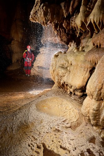 Grotte de l'Olivier (Lot) - Dôme de calcite avec micro gours, et spéléo en arrière plan(SP-23-1794)
