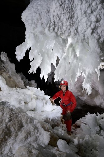 Grotte de Geophysicheskaya (Turkménistan) - Galerie blanche : rideau de chandeliers de  gypse avec personnage en dessous.(SP-24-0982)