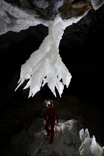 Grotte de Geophysicheskaya (Turkménistan) - Galerie blanche : chandelier de  gypse au plafond avec personnage en silhouette dessous(SP-24-0990)