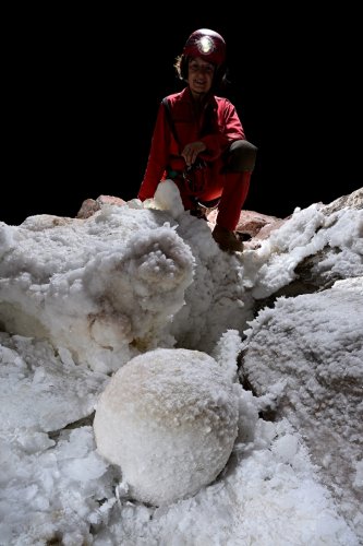 Grotte de Geophysicheskaya (Turkménistan) - Salle rose : boule de gypse  au sol avec personnage en fond.(SP-24-1019)