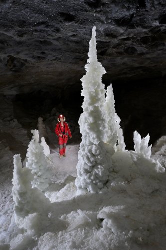 Grotte de Geophysicheskaya (Turkménistan) - Salle blanche : grande stalagmite avec personnage en arrière-plan.(SP-24-1044)