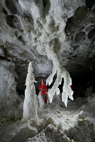 Grotte de Geophysicheskaya (Turkménistan) - Salle blanche : chandelier géant et stalagmites de gypse avec personnage en arrière plan.(SP-24-1052)