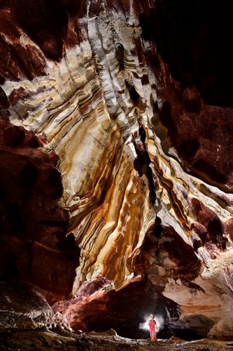 Grotte de Geophysicheskaya (Turkménistan) - Galerie rouge : parois couvertes de draperies colorées (avec personnage en arrière plan).(SP-24-1057)