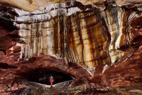 Grotte de Geophysicheskaya (Turkménistan) - Galerie rouge : paroi couverte de draperies colorées (avec personnage dans conduit).(SP-24-1059)