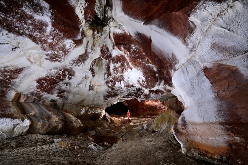 Grotte de Geophysicheskaya (Turkménistan) - Galerie rouge : passage avec plafond rouge strié de gypse (personnage en arrière plan). (SP-24-1098)