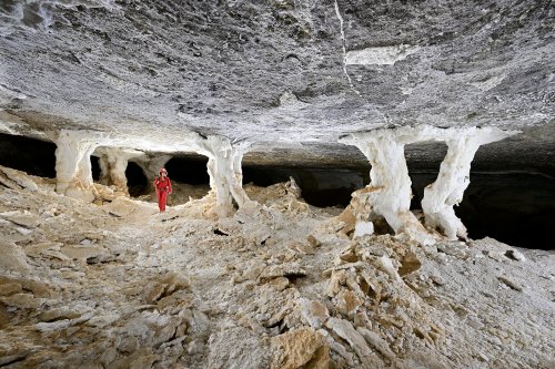 Grotte d'Hushm-Oyeek (Turkménistan) - Galerie avec piliers de gypse massifs et plaques de gypse effondrées au sol (avec personnage).(SP-24-1119)