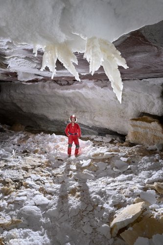 Grotte de Geophysicheskaya (Turkménistan) - Galerie entièrement recouverte de gypse avec cristaux géants au plafond et personnage en fond.(SP-24-1193)