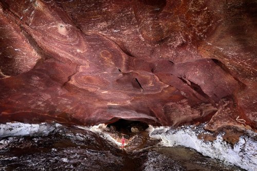 Grotte de Geophysicheskaya (Turkménistan) - Galerie rouge : galerie au plafond rouge et gypse sur les parois (personnage en arrière plan).(SP-24-1328)