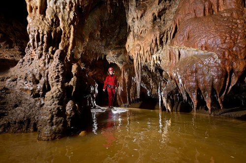 Beke cave (Hongrie) - Rivière dans un passage concrétionné avec personnage en fond(SP-24-1965)