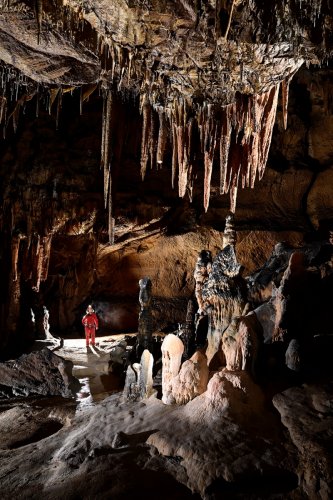 Baradla barlang (Hongrie) - Passage avec ensemble de stalactites au dessus de gours blancs avec spéléo en fond (SP-24-2069)