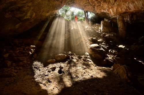 Gcwihaba cave entrée nord (Botswana) - Rayons de soleil pénétrant dans l'entrée (avec spéléo perché en haut).(SP-25-0878)
