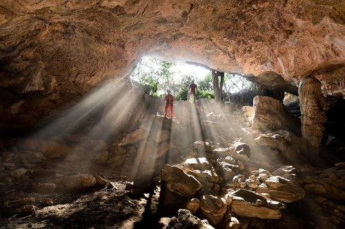 Gcwihaba cave entrée nord (Botswana) - Rayons de soleil pénétrant dans l'entrée (avec deux spéléos dans les rayons de soleil).(SP-25-0907)