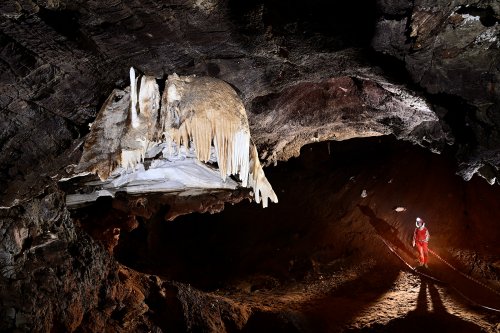 Gecko cave (Botswana) - Coulées de calcite suspendues au plafond avec spéléo en contrebas.(SP-25-1004)