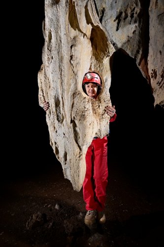 Gcwihaba cave (Botswana) - Stalactite massive percée par la corrosion (avec spéléo derrière)(SP-25-1137)
