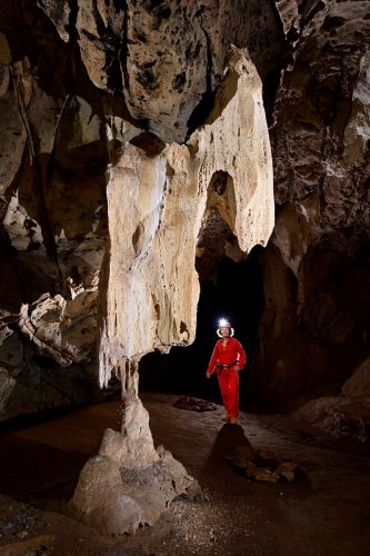 Gcwihaba cave (Botswana) - Concrétion sculptées par la corrosion (avec spéléo en fond dans la galerie)(SP-25-1161)