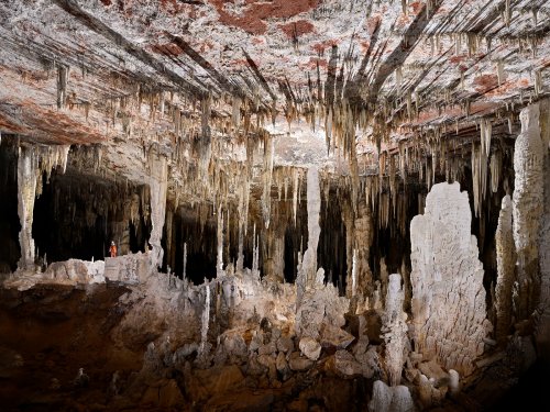 Lapa Terra Ronca (Goias, Brésil) - Grande salle avec des colonnes blanches (spéléo perché en fond à gauche).(SP-25-1516)