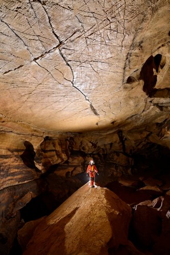 Grotte des Claris (Gard) - Spéléo progressant sur une arrête rocheuse dans une galerie au plafond plat (verticale)(SP-25-2347)
