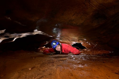 Grotte des Claris (Gard) - Spéléo rampant dans un passage étroit(SP-25-2364)