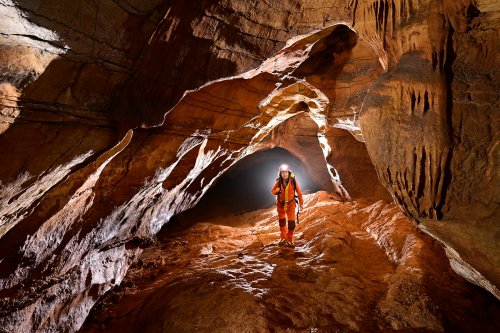 Grotte des Claris (Gard) - Spéléo progressant dans la Galerie d'entrée (horizontale - premier plan éclairé)(SP-25-237)