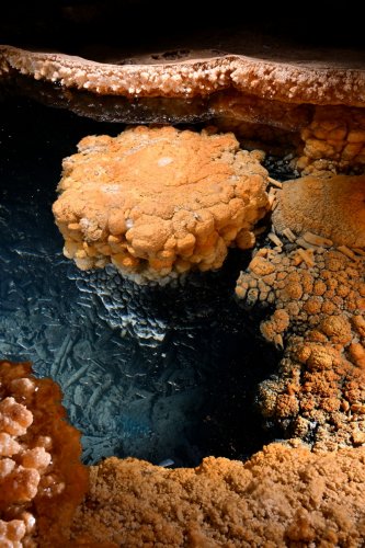 Grotte Flandin (Ardèche) - Cristallisations à la surface d'un petit gour(SP-25-2389)