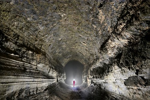 Tunel Bella Vista (Santa Cruz, Galapagos, Equateur) - Grand tube de lave rectangulaire avec parois striées (personnage éclairé)(SP-26-0165)