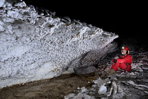 Grotte de Geophysicheskaya (Turkménistan) - Personnage assis devant une paroi couverte de petites boules de gypse.(SP-26-0329)