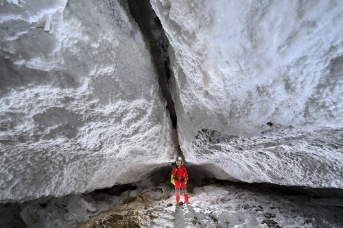 Grotte de Geophysicheskaya (Turkménistan) - Galerie en diaclase aux parois couvertes de gypse (personnage en fond)(SP-26-0733)