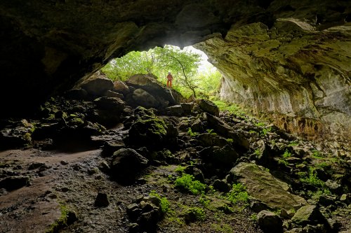 Cueva Coventosa (Cantabrie, Espagne) - Entrée de la grotte vue de l'intérieur avec spéléo en fond(SP-26-0874)