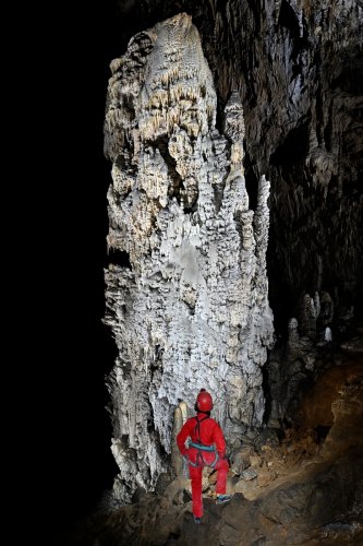 Cueva Coventosa (Cantabrie, Espagne) - Grande colonne grise concrétionnée avec spéléo en premier plan(SP-26-0904)