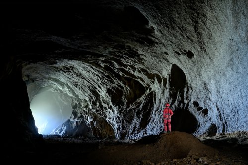Cueva Canuela (Cantabrie, Espagne) - Entrée vue de l'intérieur avec brouillard (personnage perché de dos à droite)(SP-26-0982)