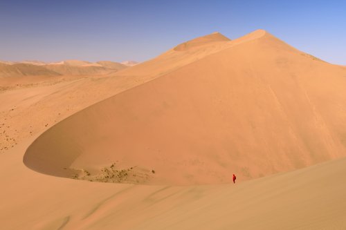 Désert du Badain Jaran (Chine, Mongolie Intérieure) - Randonneuse au loin  sur la crête d'une grande dune formant une large échancrure.(VO-16-0902)