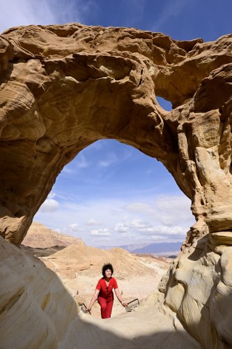 Parc national de Timna (Israël) - Personnage derrière une arche naturelle avec paysage en fond(VO-23-0287)